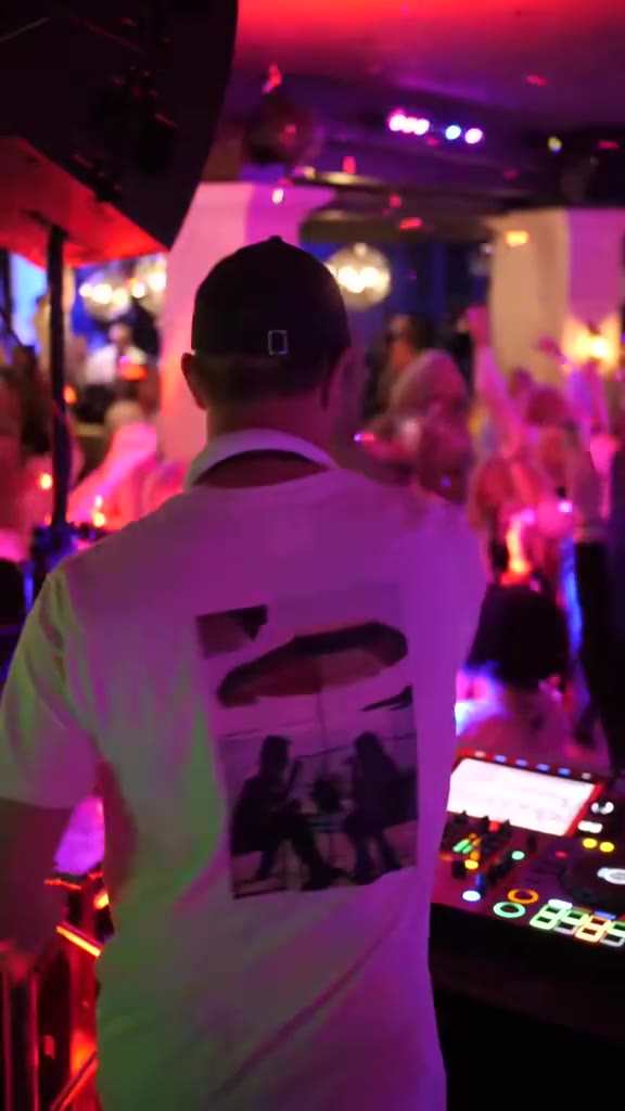 Niklas bakom mixerbordet framför ett fullt dansgolv